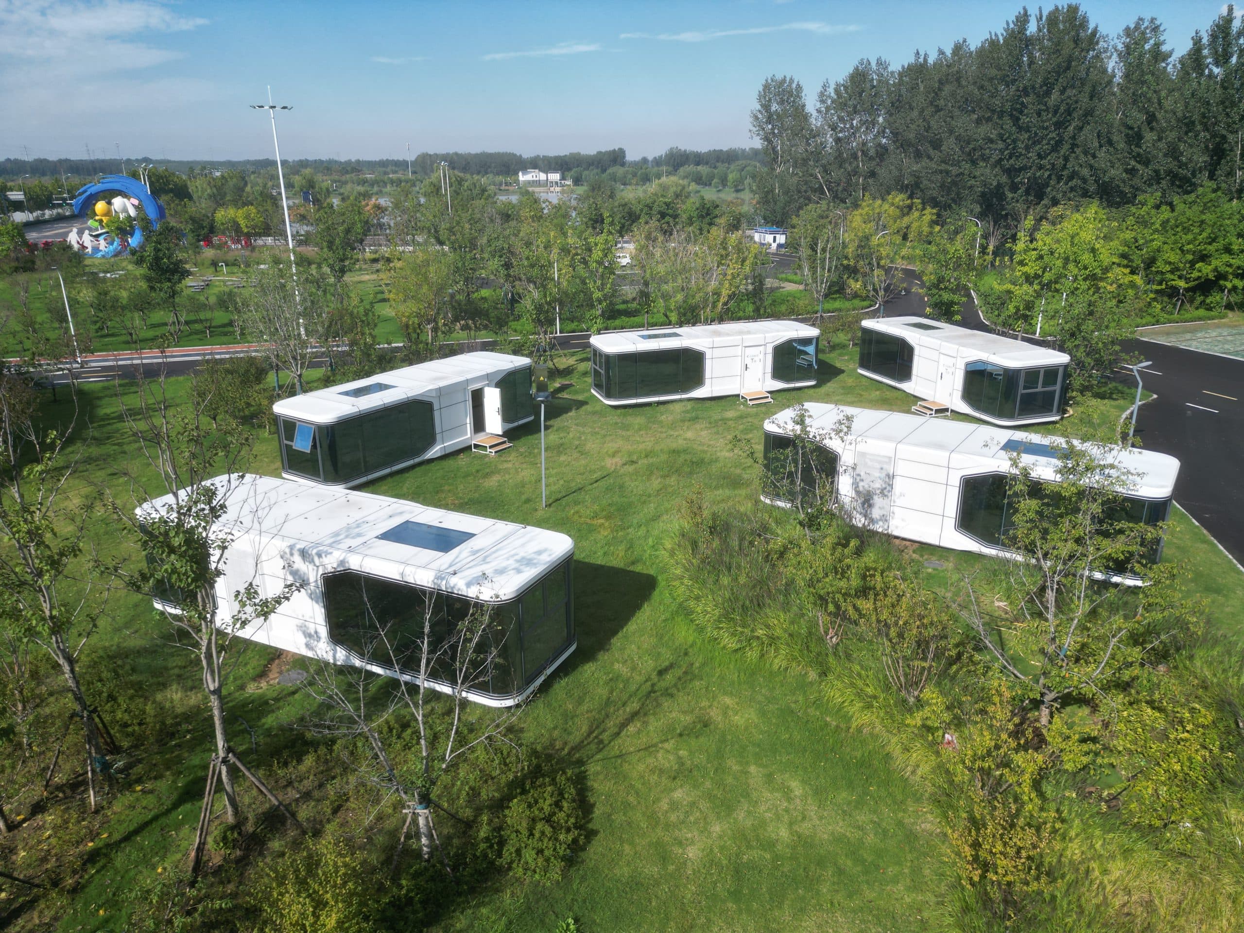 Real project photograph of KSD capsule cabins arranged within a landscaped green site